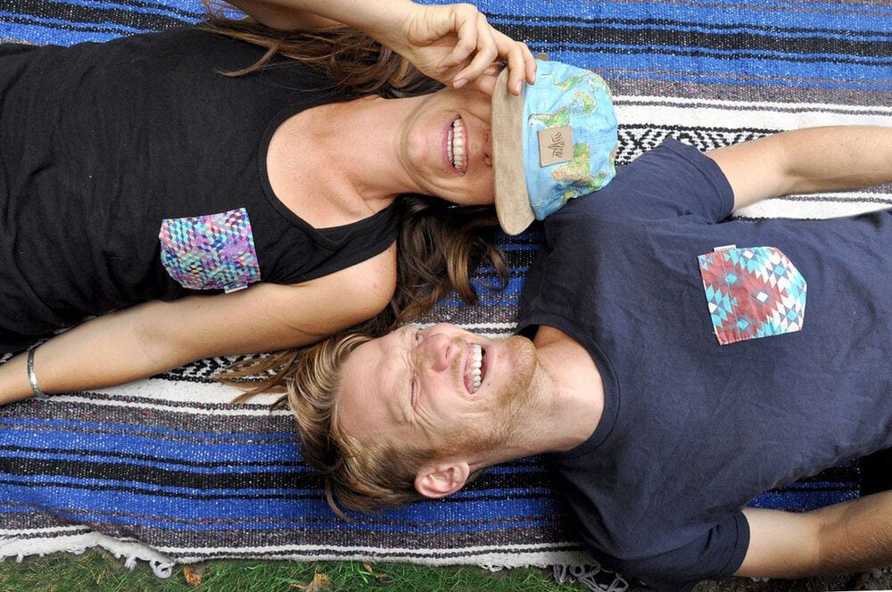 Laying on a picnic blanket laughing Katie and Ben