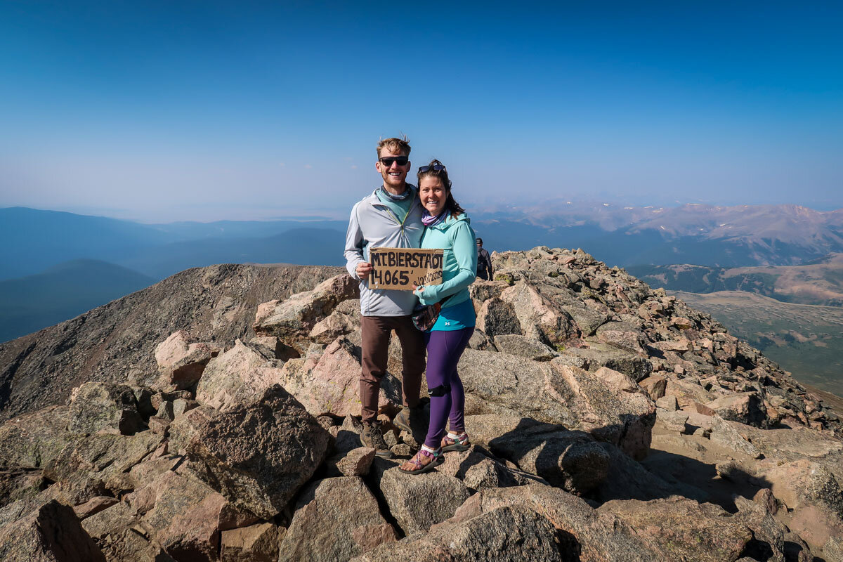 At the summit of Mount Bierstadt. A friendly stranger asked if we wanted to borrow his sign for a picture (in exchange for taking his photo). We gladly obliged!
