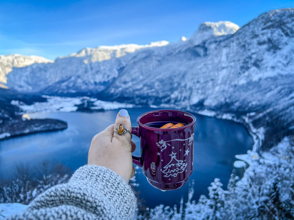 Cheers-ing with gluhwein overlooking the lake in Hallstatt, Austria