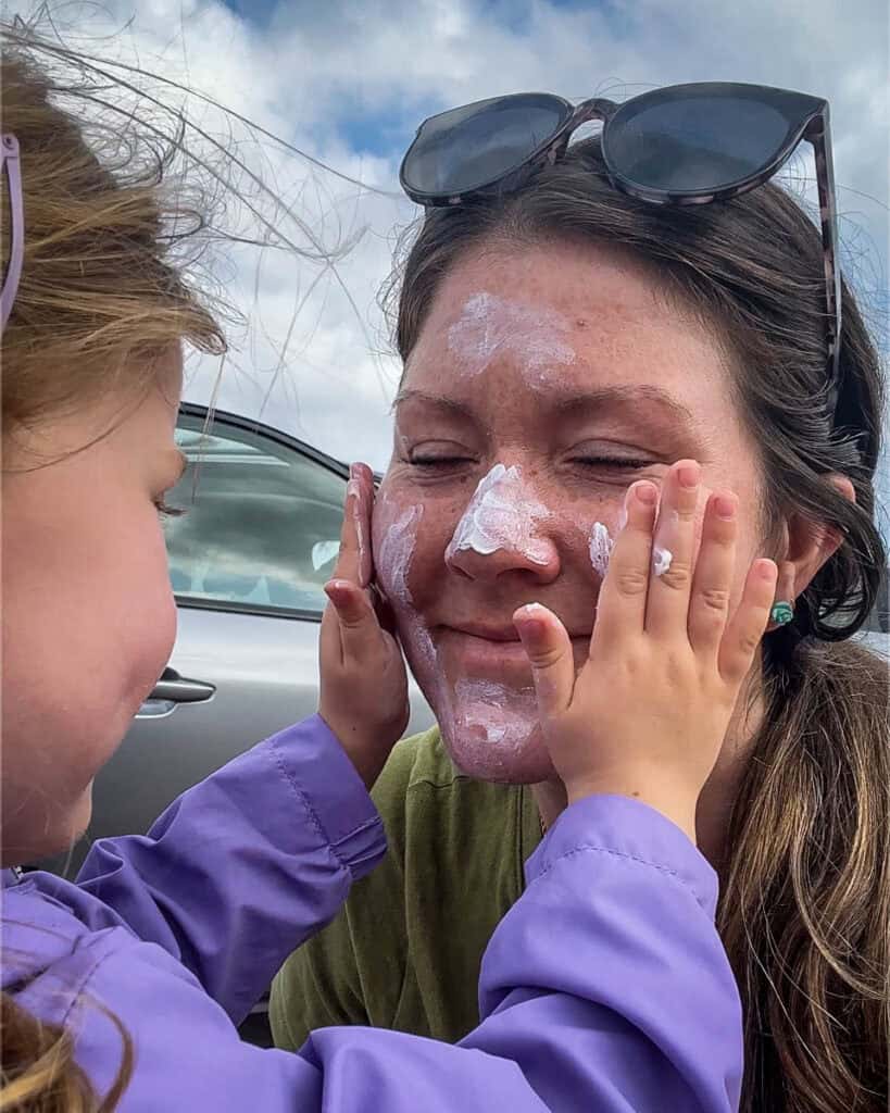 Juniper putting sunscreen on Katie's face